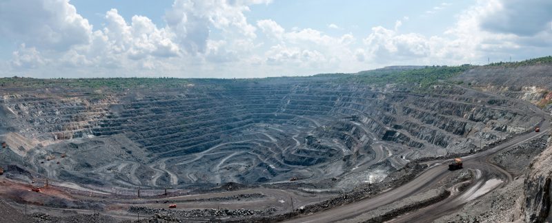37151779 - panorama of quarry extracting iron ore with heavy trucks, excavators, diggers and locomotives